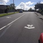 Properly located sharrows will steer bikes out past parked cars (c/ Akld Transport)